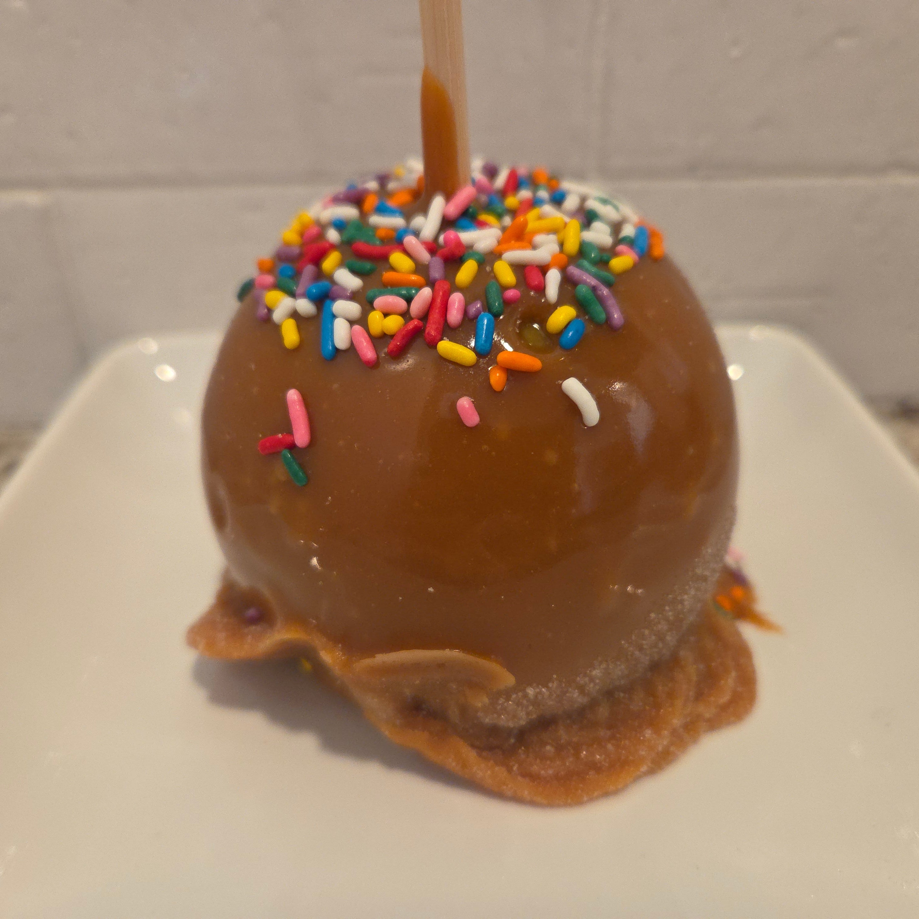 Traditional Caramel Apple covered in colorful sprinkles